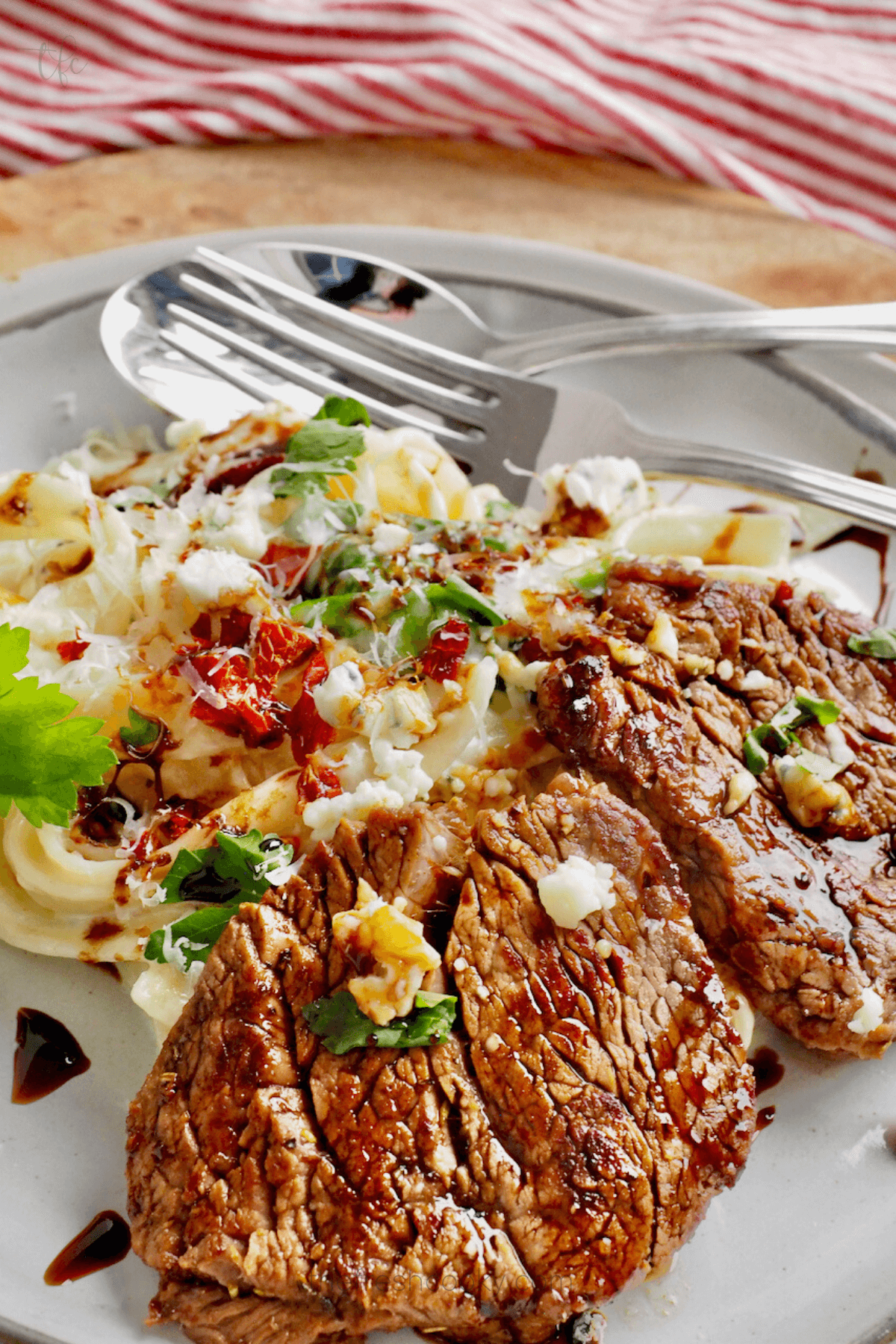 Olive Garden Steak Gorgonzola Alfredo plated with steaks drizzled with balsamic glaze.