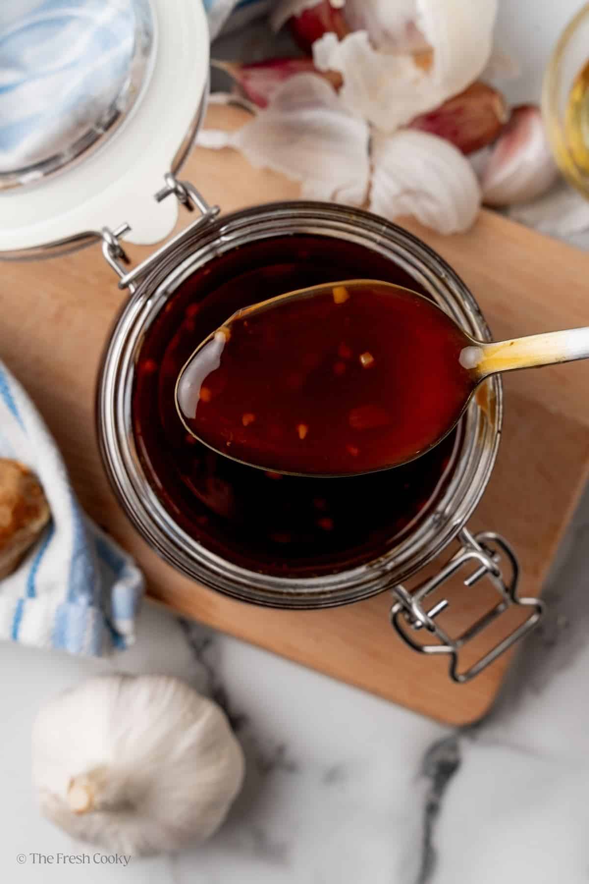 Spoonful of glossy teriyaki sauce. 