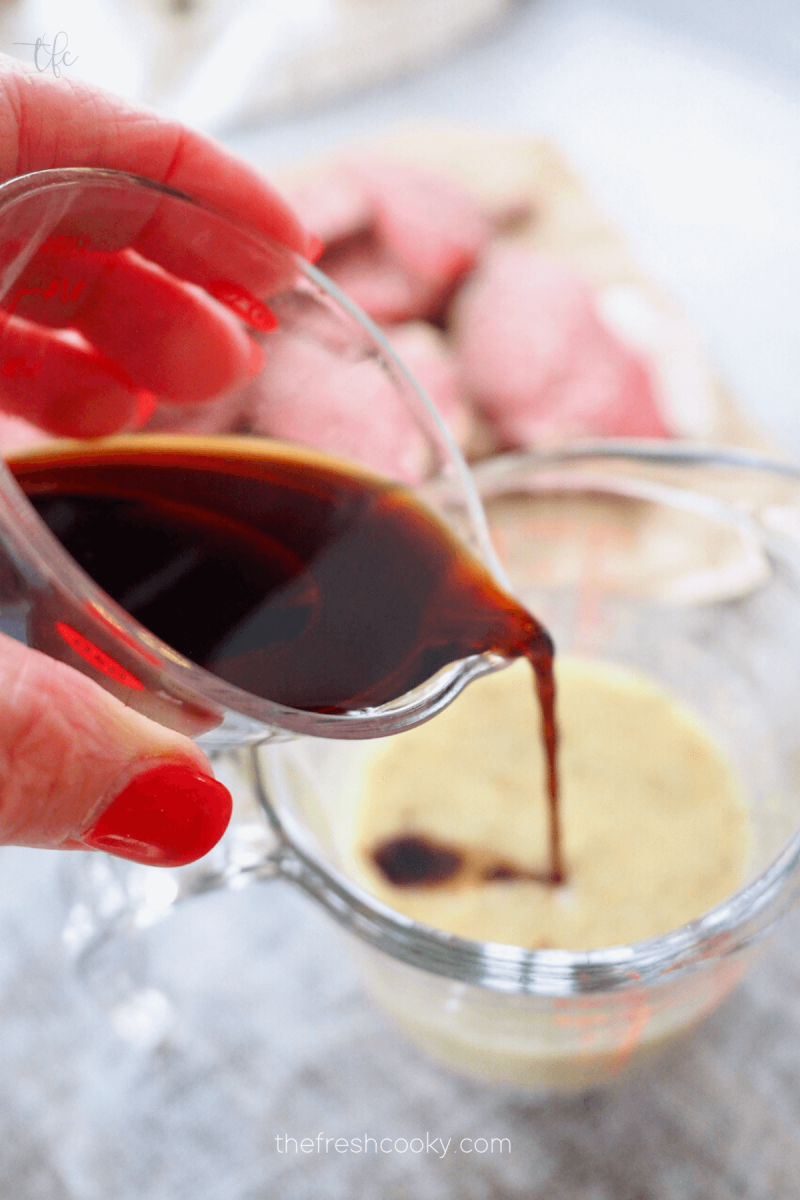 Pouring in balsamic vinegar into Italian dressing. 