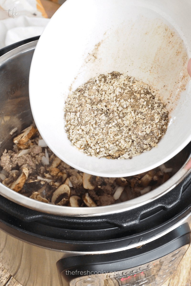 Stir in spices for Instant Pot Ground Beef Stroganoff.