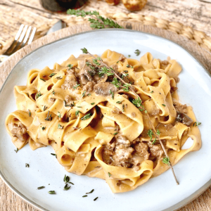 Instant Pot ground beef stroganoff on plate with fresh thyme.