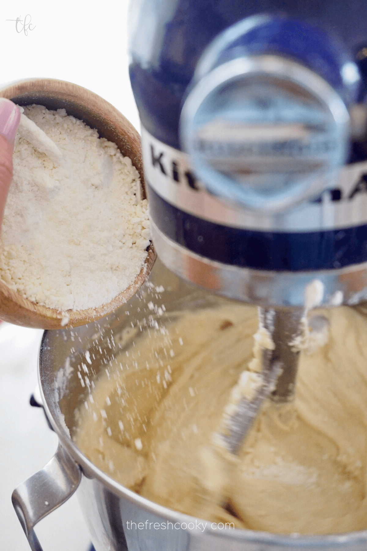 Pouring in ground white chocolate to batter.