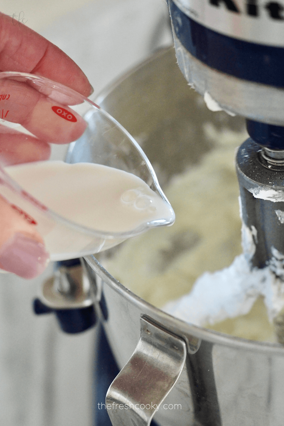 Adding lemon juice to cream cheese frosting mixture. 