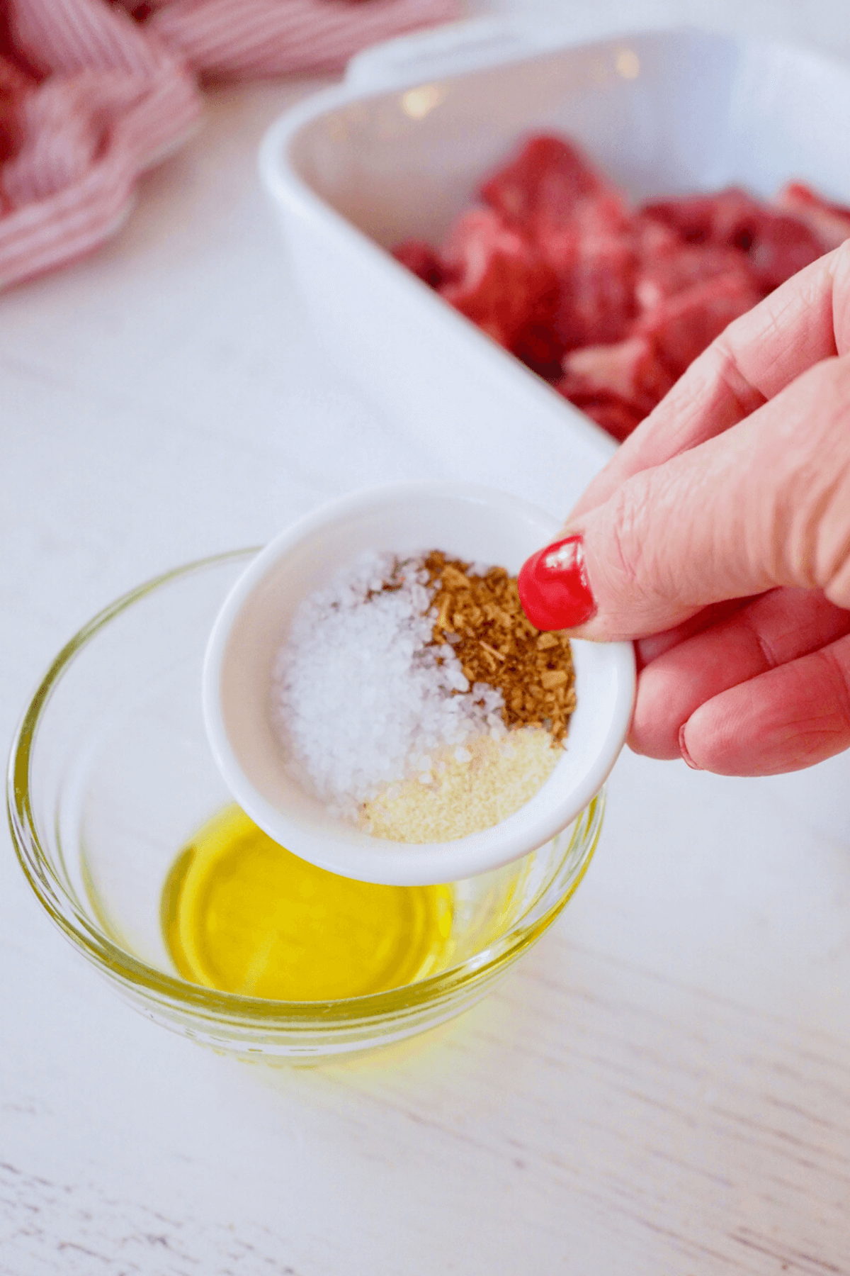 Adding seasonings for air fryer steak tips to oil.
