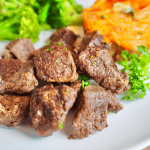 Air Fryer Steak Bites (Tips) Square Image with sweet potato and broccoli in background.