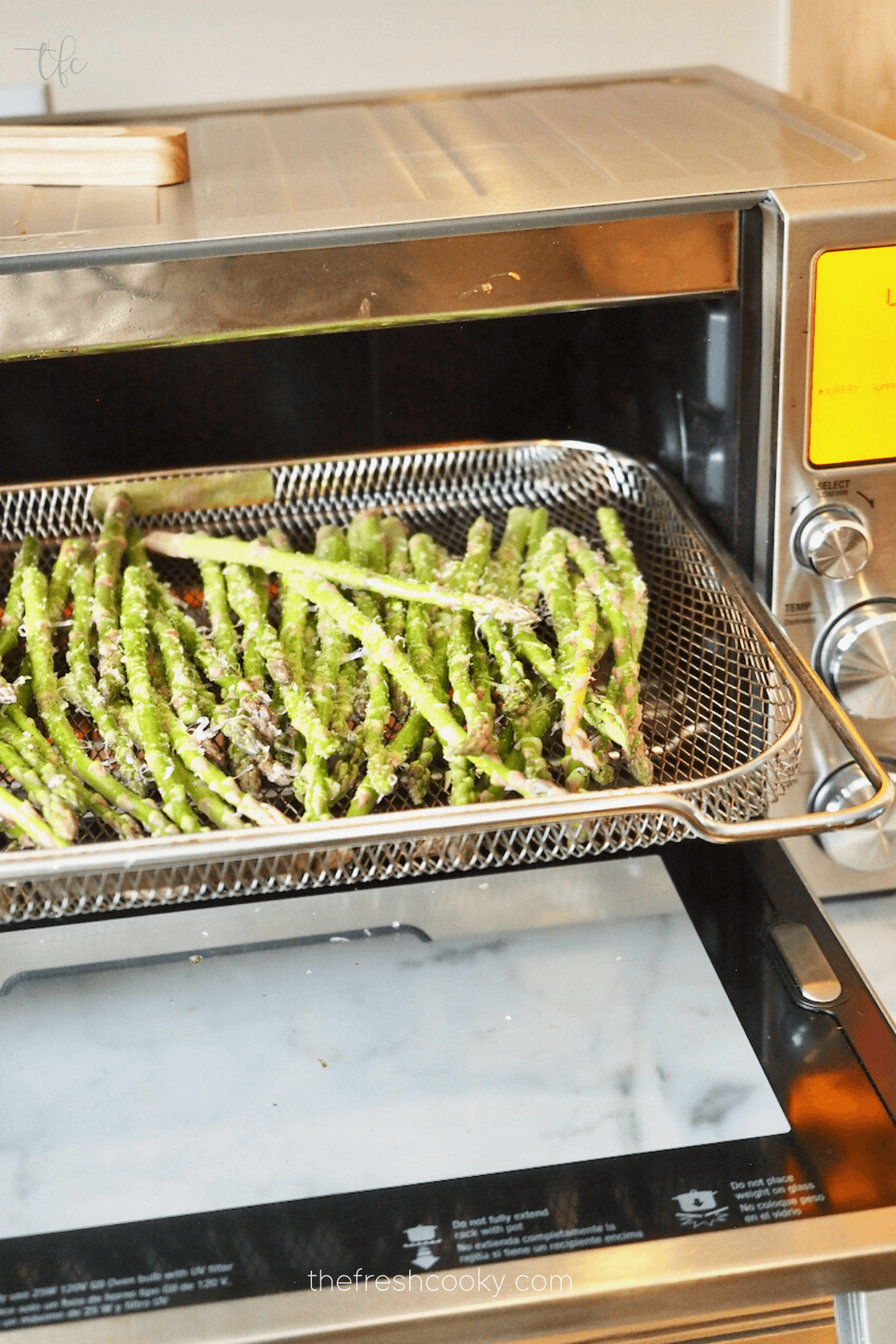 Asparagus in air fryer basket ready to roast.