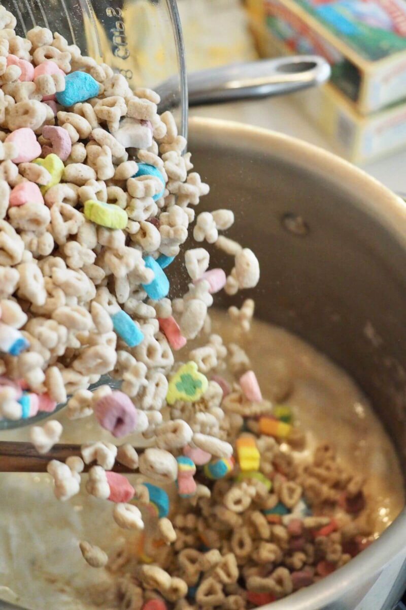 Add Lucky Charms cereal all at once into melted marshmallow goo.