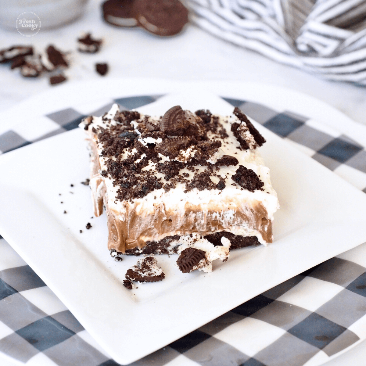 Oreo Dessert square on plate with cookie crumbs.