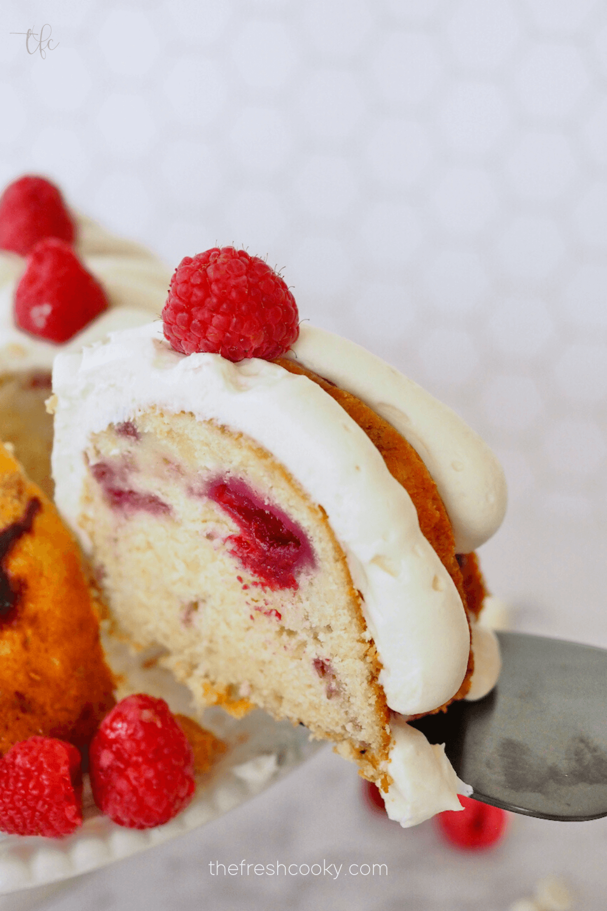 Cake server removing slice from bundt cake.