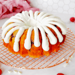 Square image of white chocolate raspberry bundt cake with copycat nothing bundt cake fingers of cream cheese frosting.