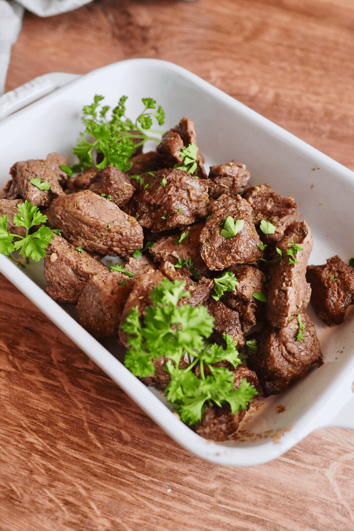 Air fryer steak bites in porcelain pan.