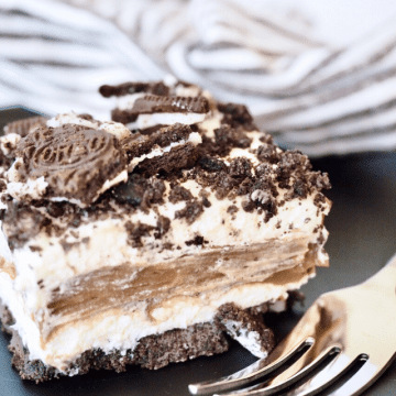 Slice or Oreo cake on black plate with fork, creamy and sot, no bake Easter dessert.