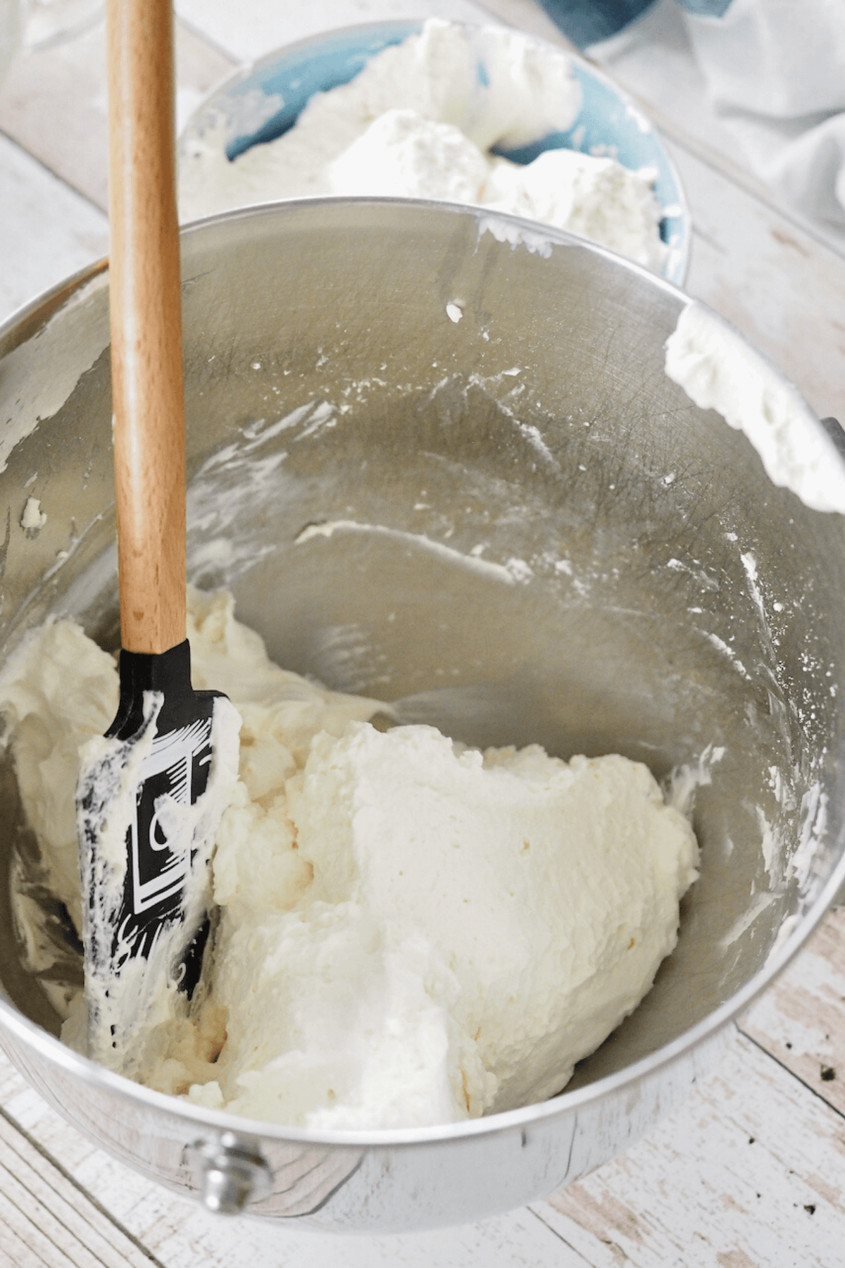 Folding homemade cool whip into cream cheese mixture.