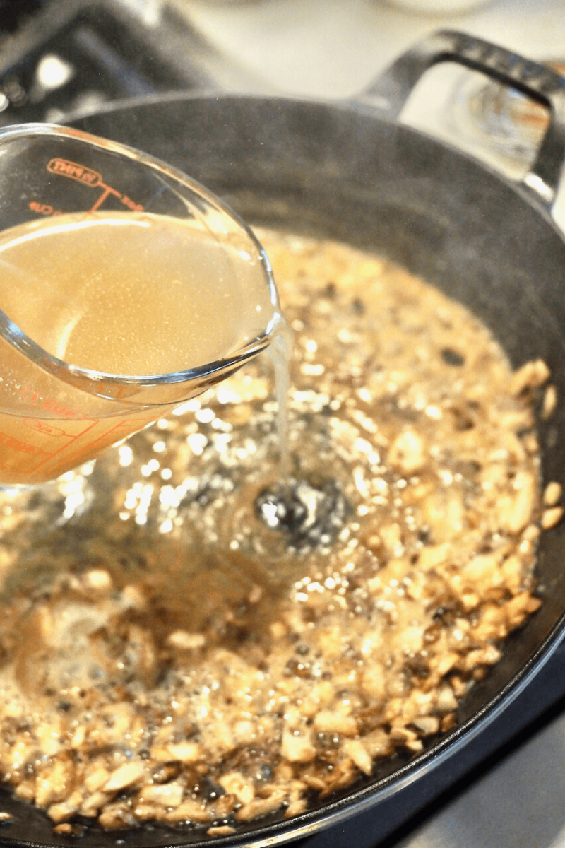 Pouring chicken broth into the butter, onion and flour mixture.