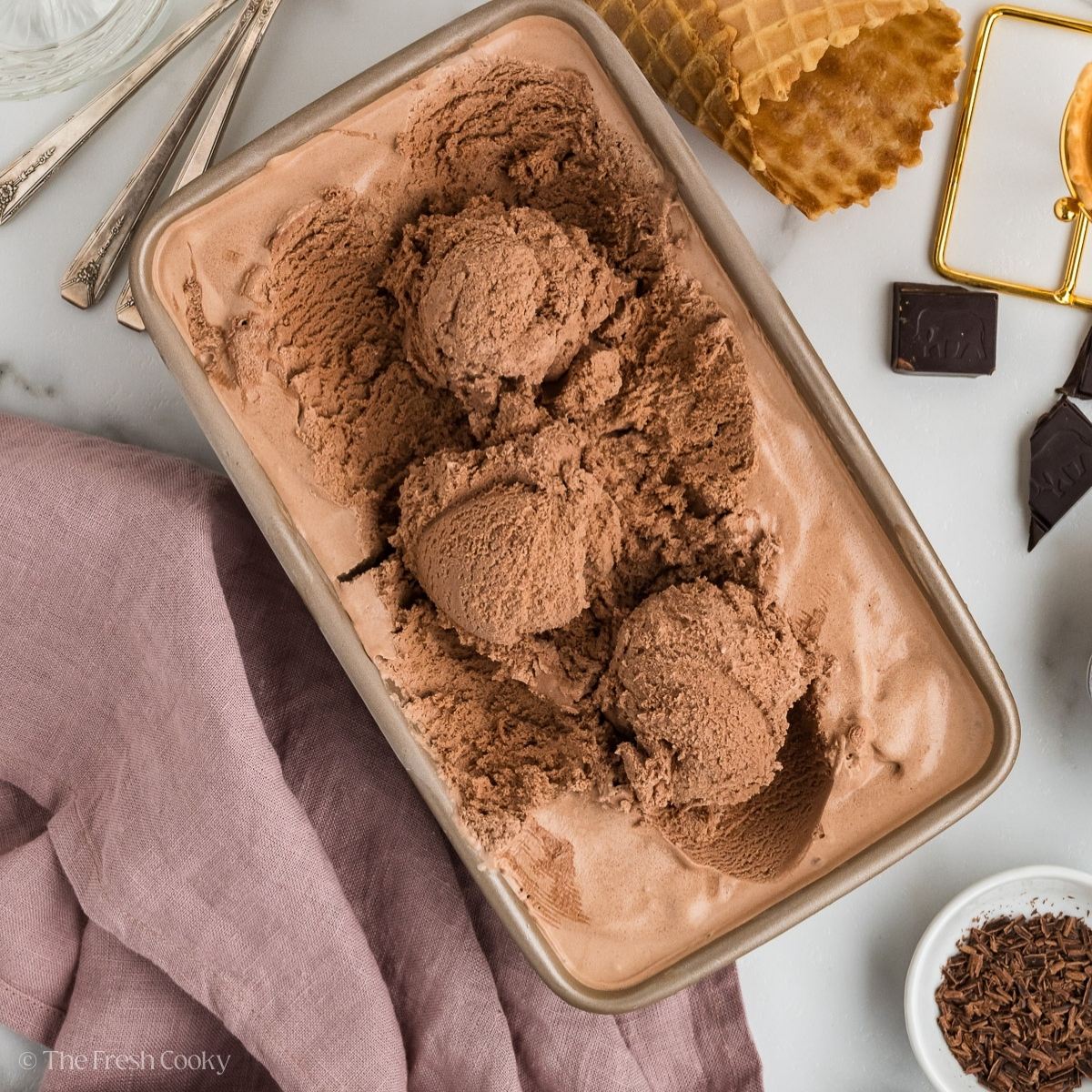 Chocolate ice cream with scoops scooped in a container.