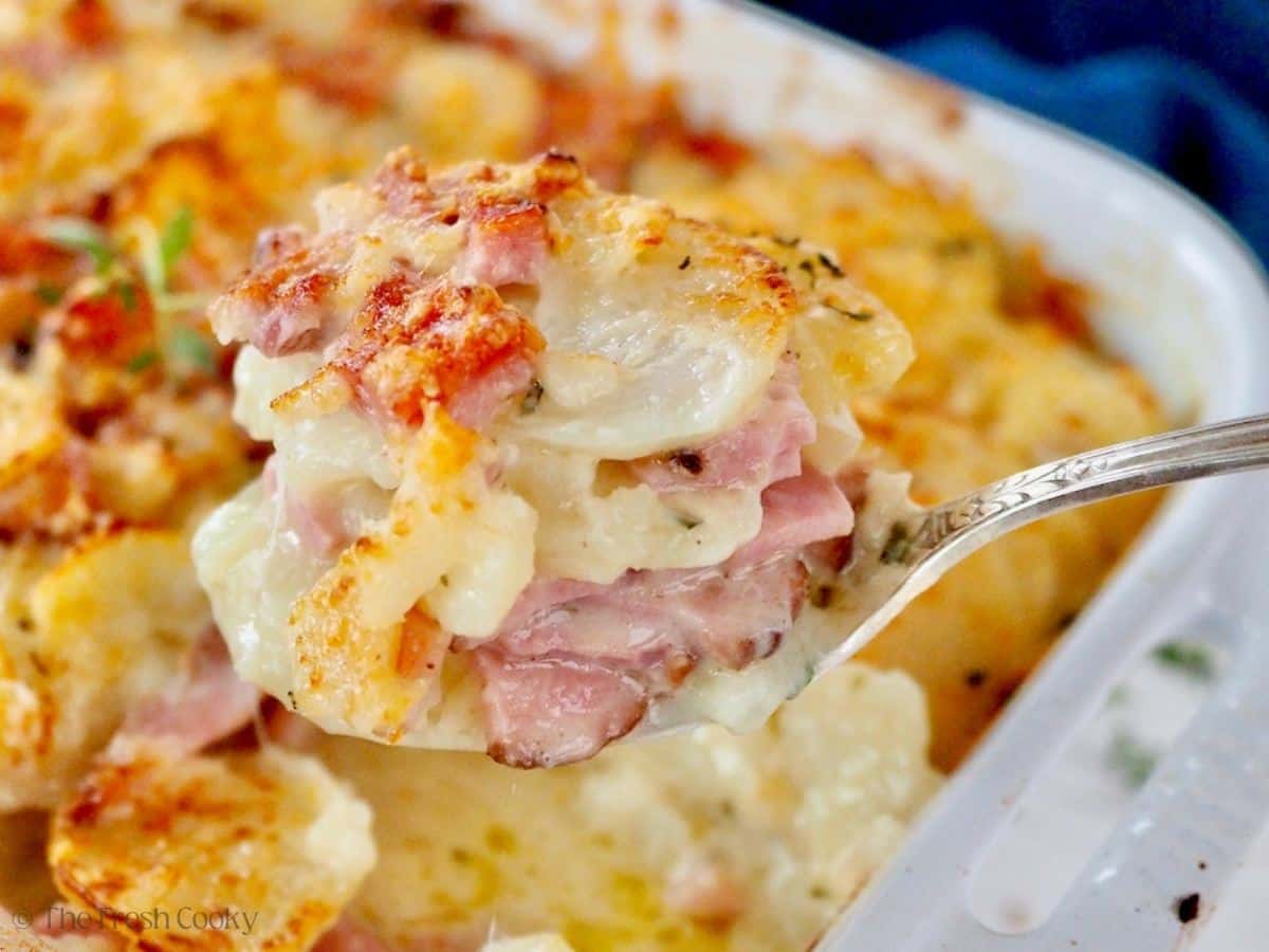 Spoon with a heaping serving of instant pot scalloped potatoes with ham.
