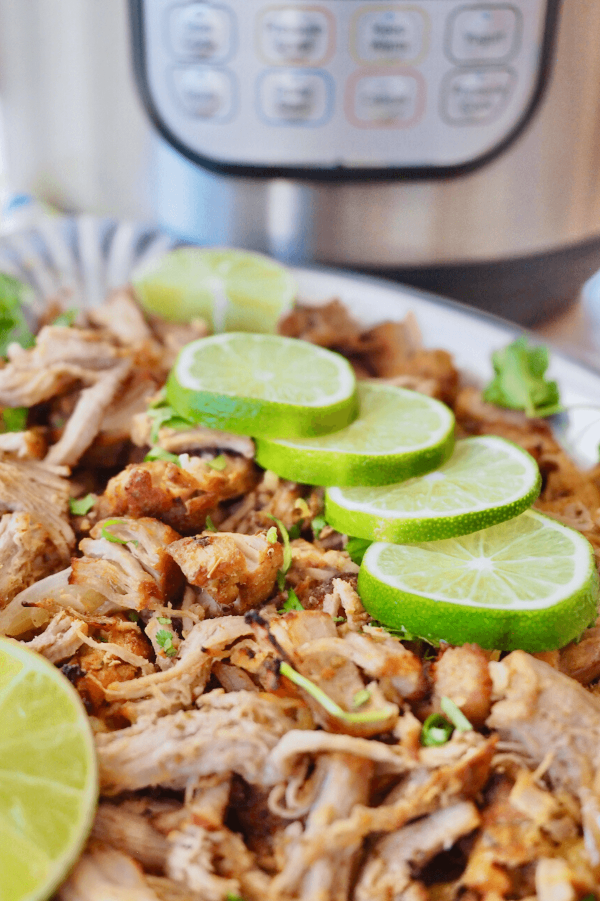 Instant Pot Carnitas on platter with instant pot in background.