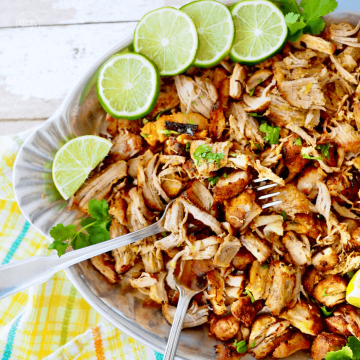 Instant Pot Carnitas on platter with slices of limes.