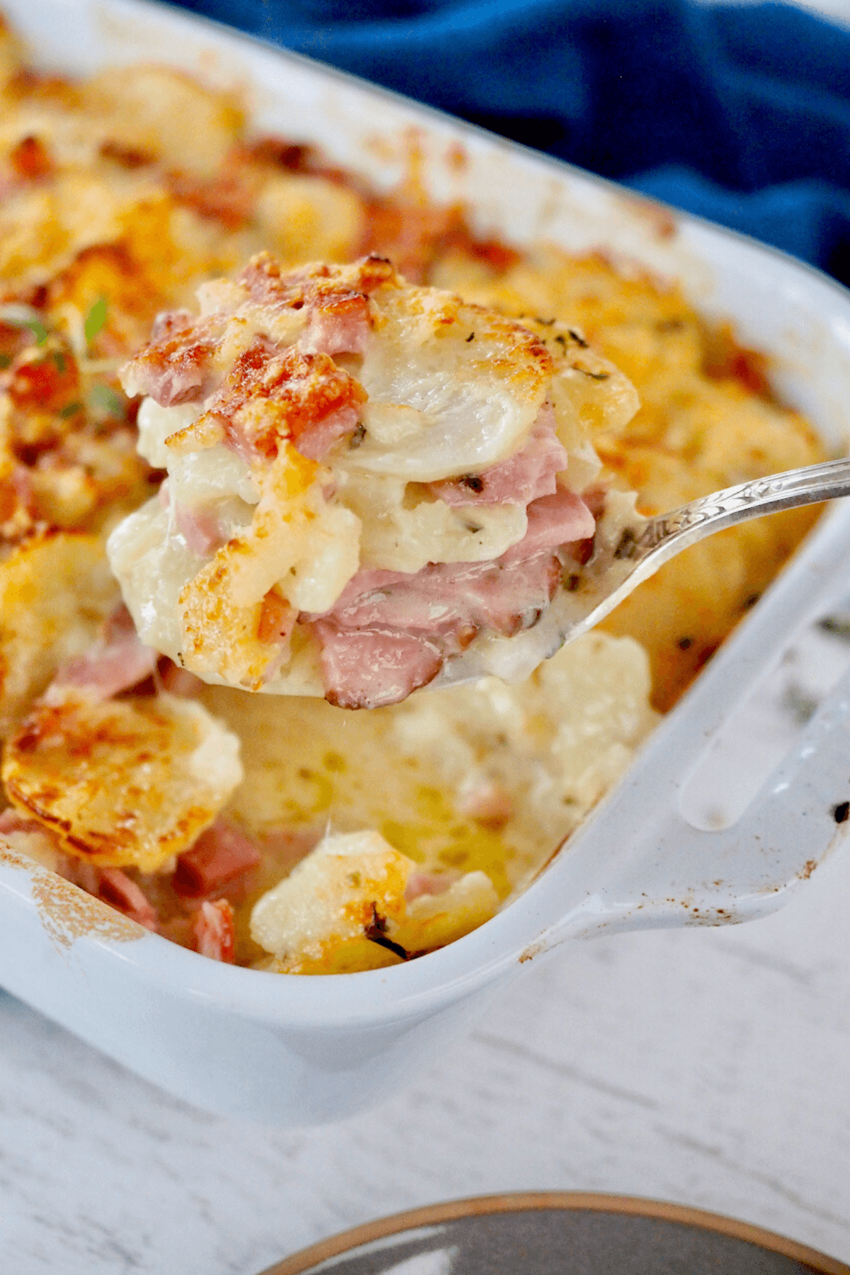 Spoon scooping out serving of Instant Pot scalloped potatoes. 