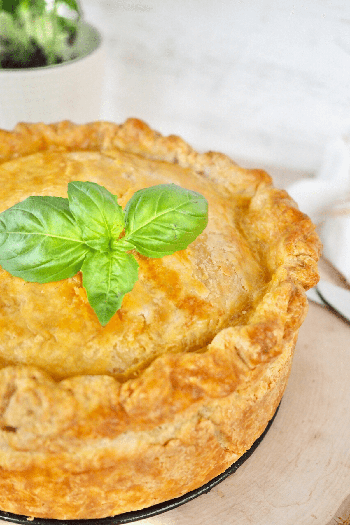 Pizza Rustica Italian Easter Pie whole pie with fresh basil on top.