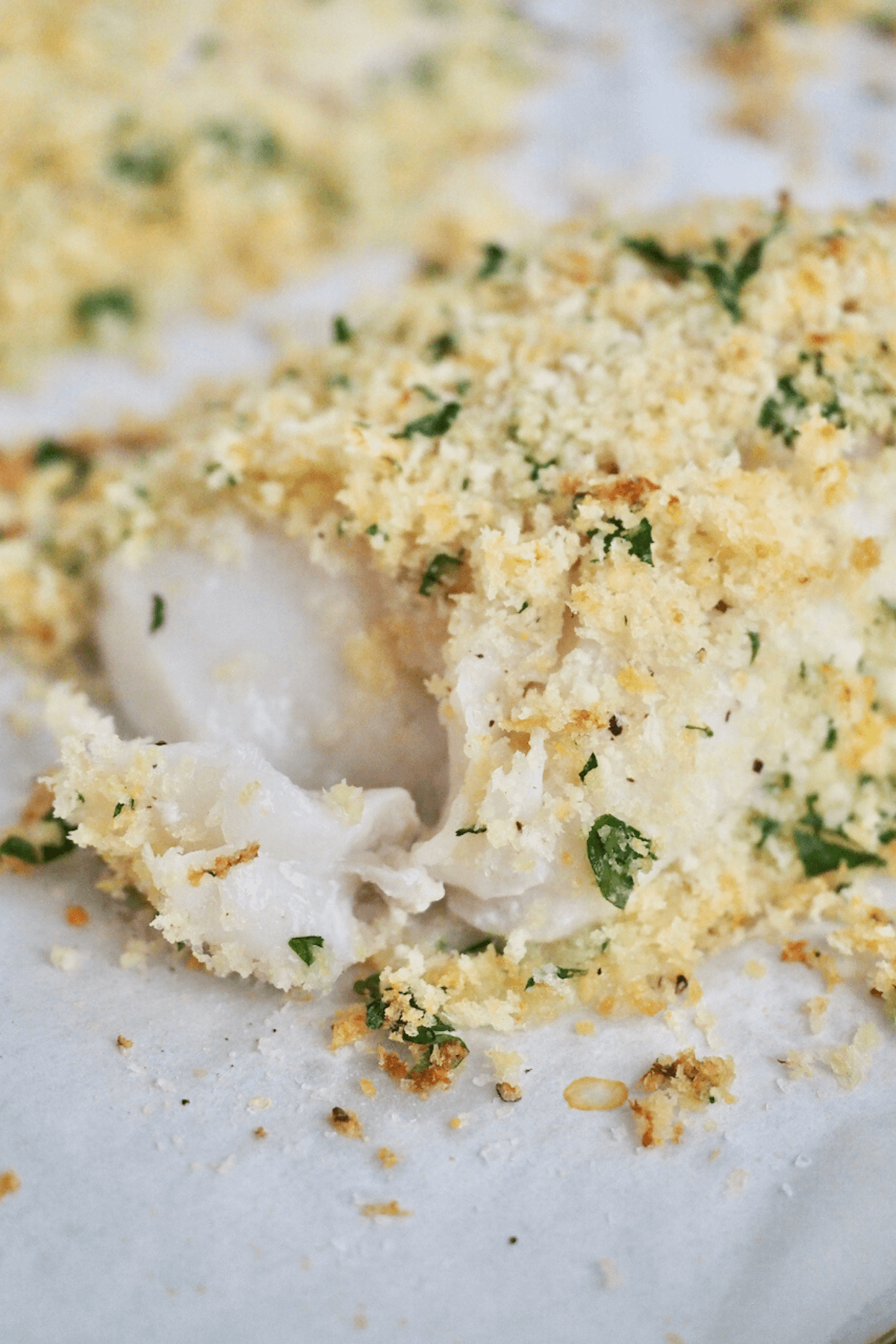 Tender flaky moist panko parmesan baked cod on plate.
