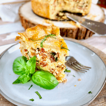 Italian Pizza Rustica Easter Pie Recipe with slice on place with fresh basil.