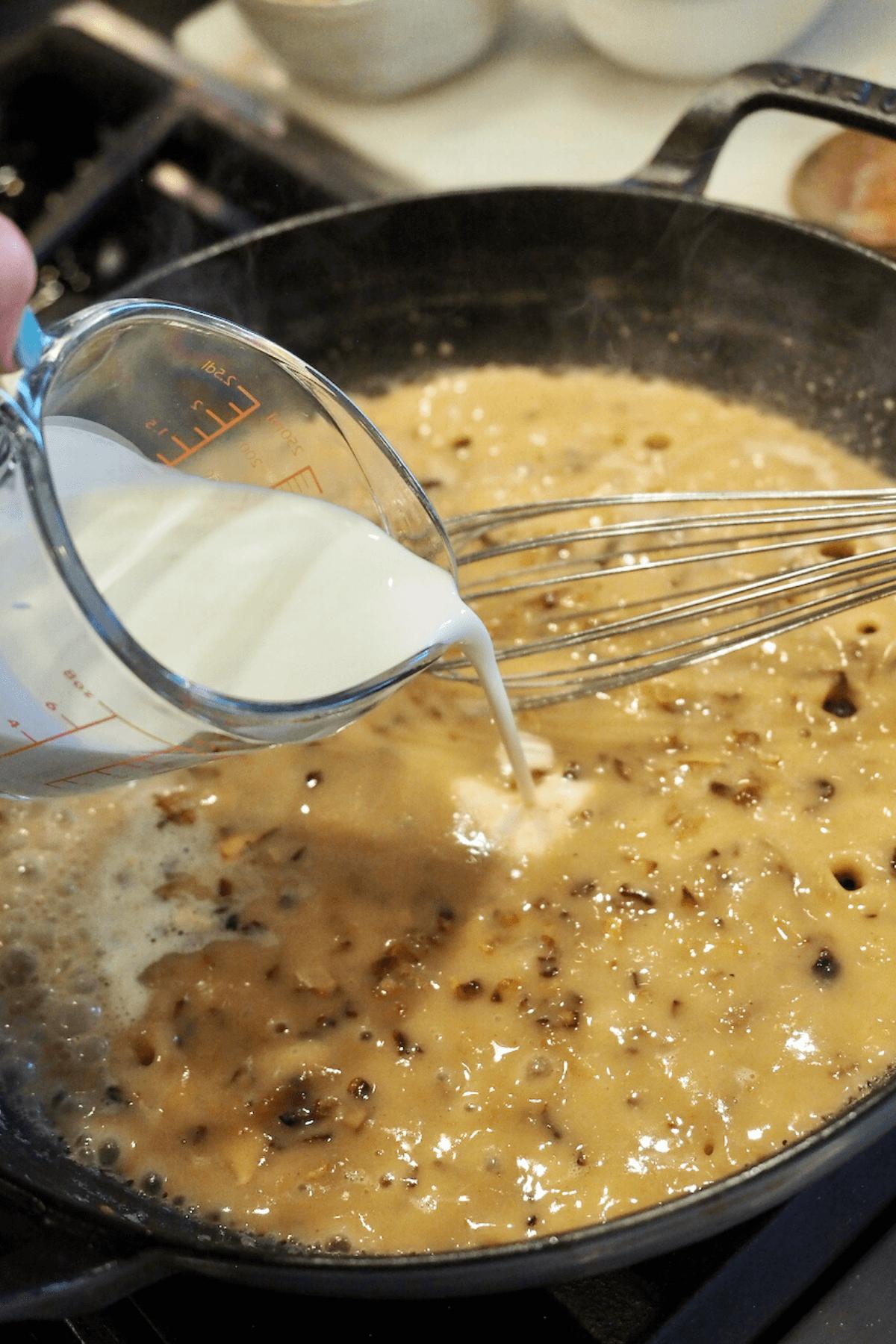 Adding cream to the flour roux mixture.