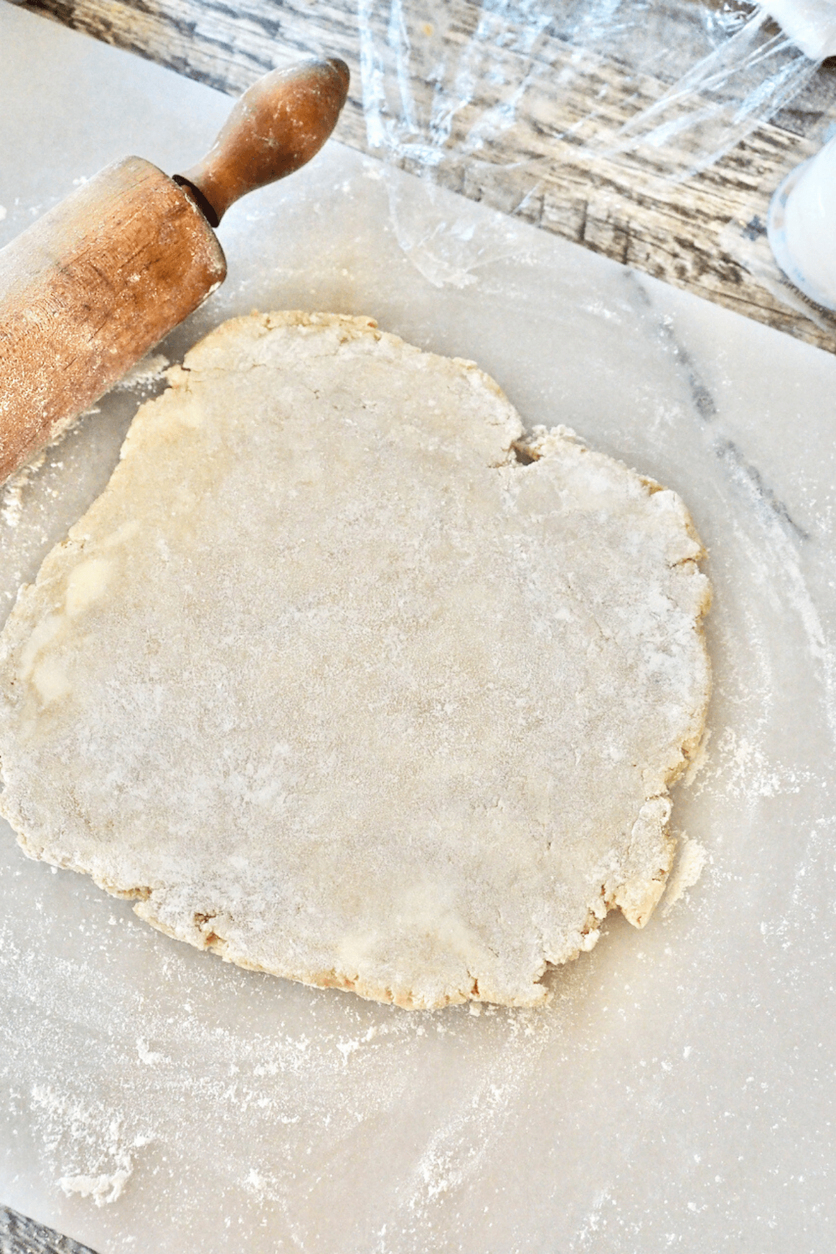 Rolling out pizza crust dough for springform pan on marble. 