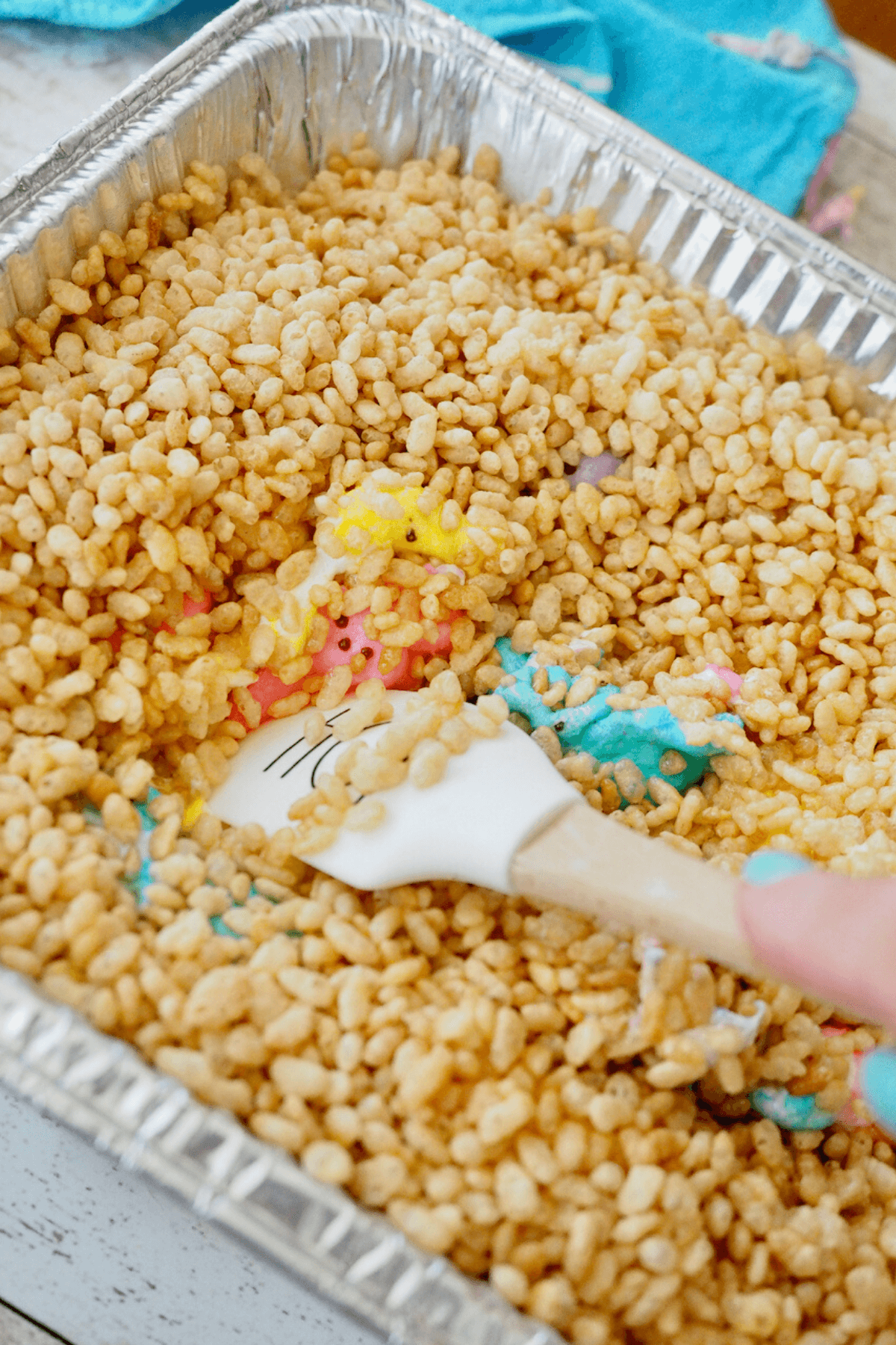 Using a spatula to stir the melted rice krispies and Peeps. 