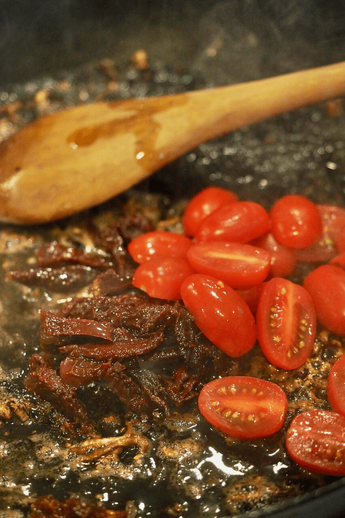 Add fresh tomatoes and stir until they start to burst. 