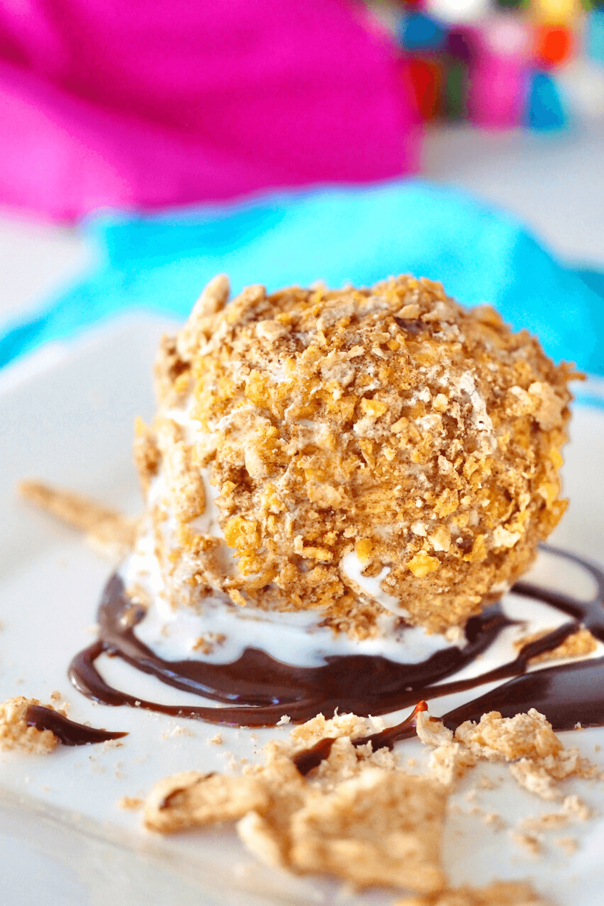 Fried Ice Cream made in air fryer on plate drizzled with hot fudge sauce.