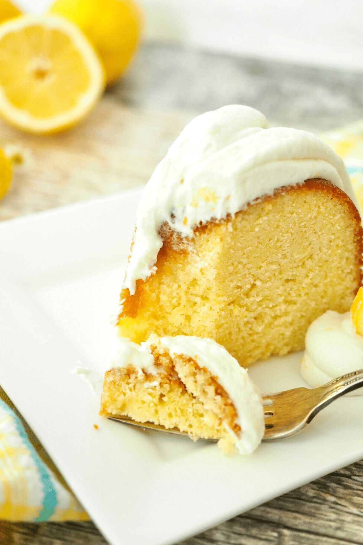 Bite on fork of lemon bundt cake with cream cheese frosting.