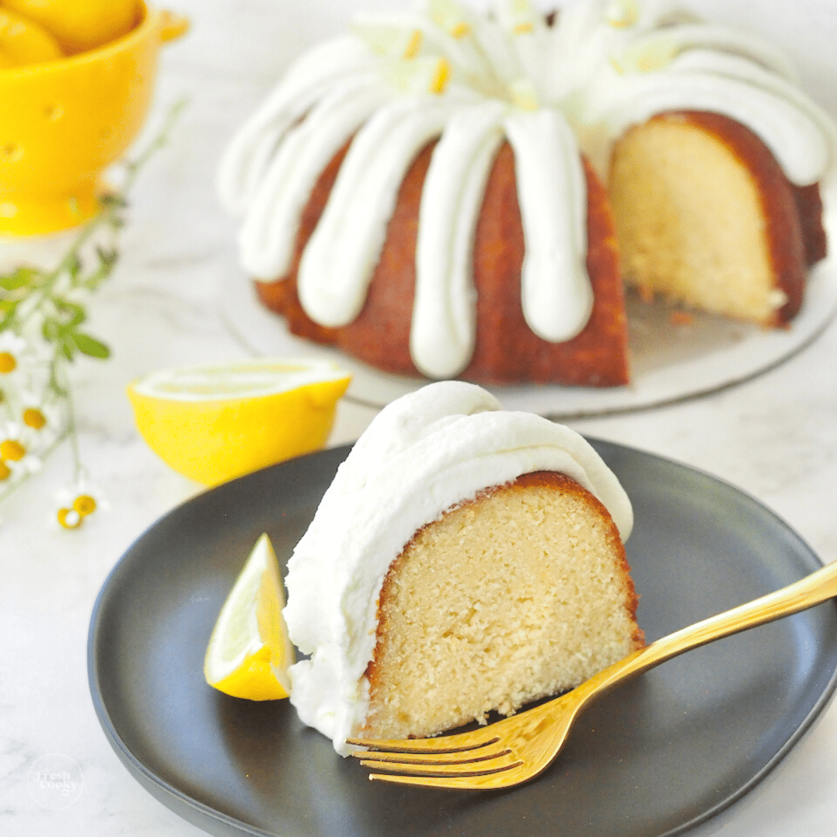 Lemonade Bundt Cake slice on plate with full bundt in background.