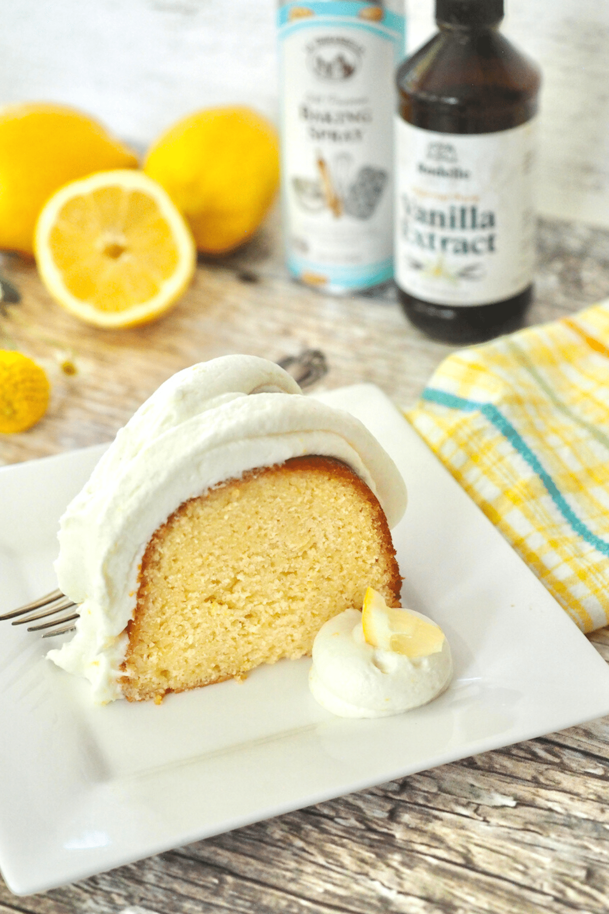 Slice of lemon bundt cake with Rodelle vanilla extract and La Tourangelle baking spray in background.
