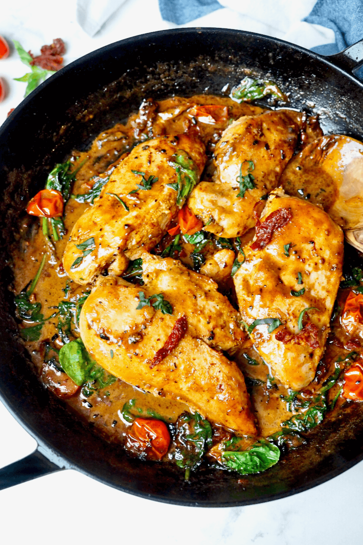 Creamy Tuscan chicken in one pan with sun dried tomatoes, fresh tomatoes and spinach in a parmesan cream sauce.