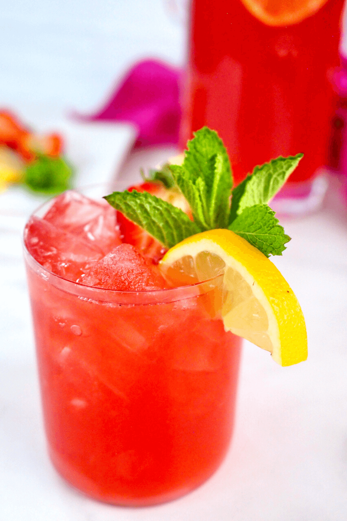 Glass filled with bright pink lemonade drink with vodka.