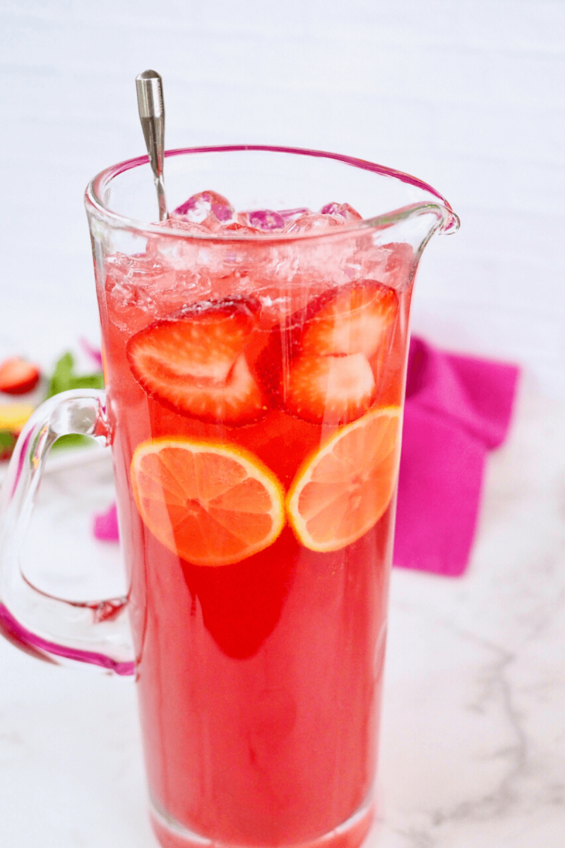 Garnished pitcher with lemon wheels and strawberry slices. 
