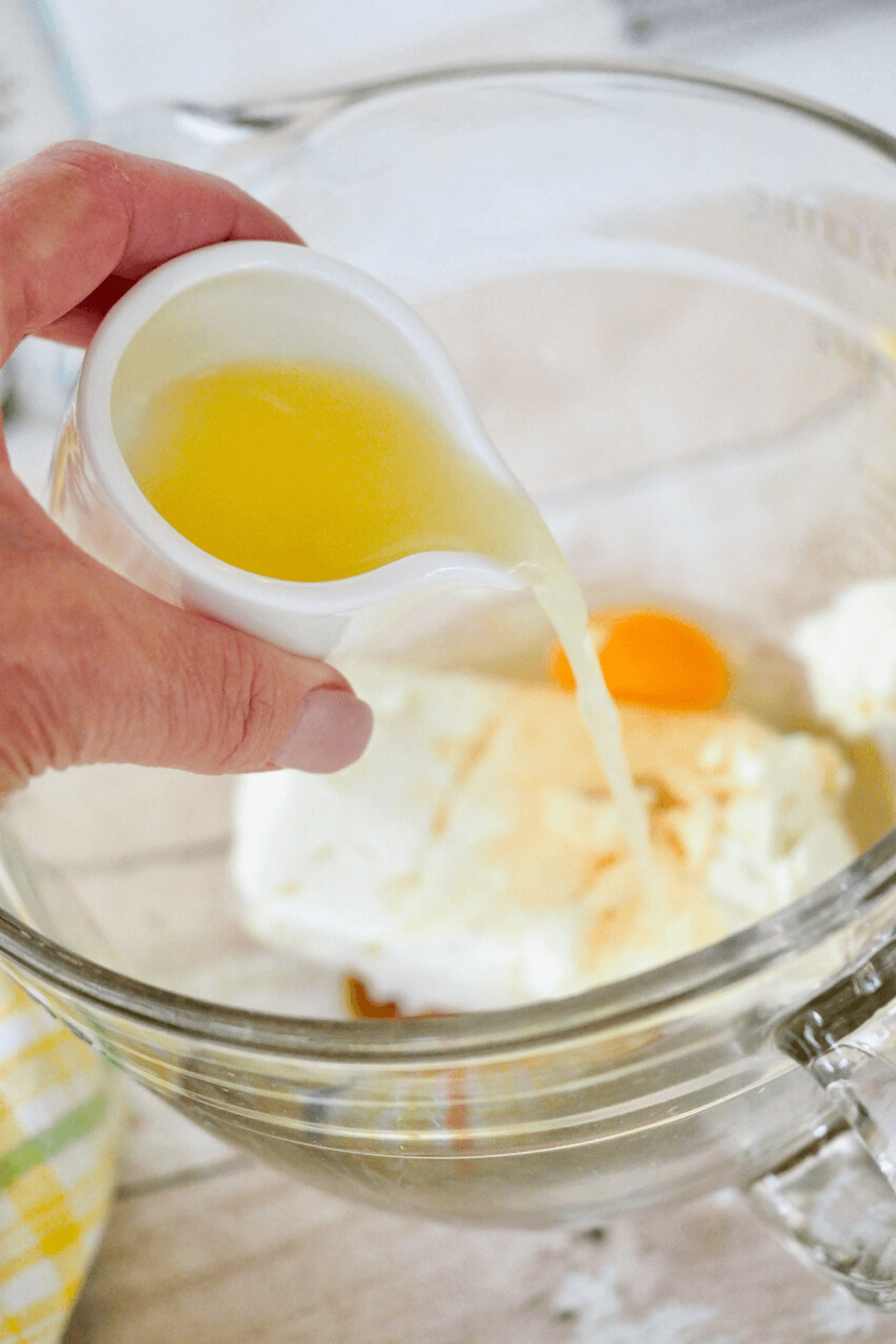 Pouring lemon juice into cream cheese mixture. 
