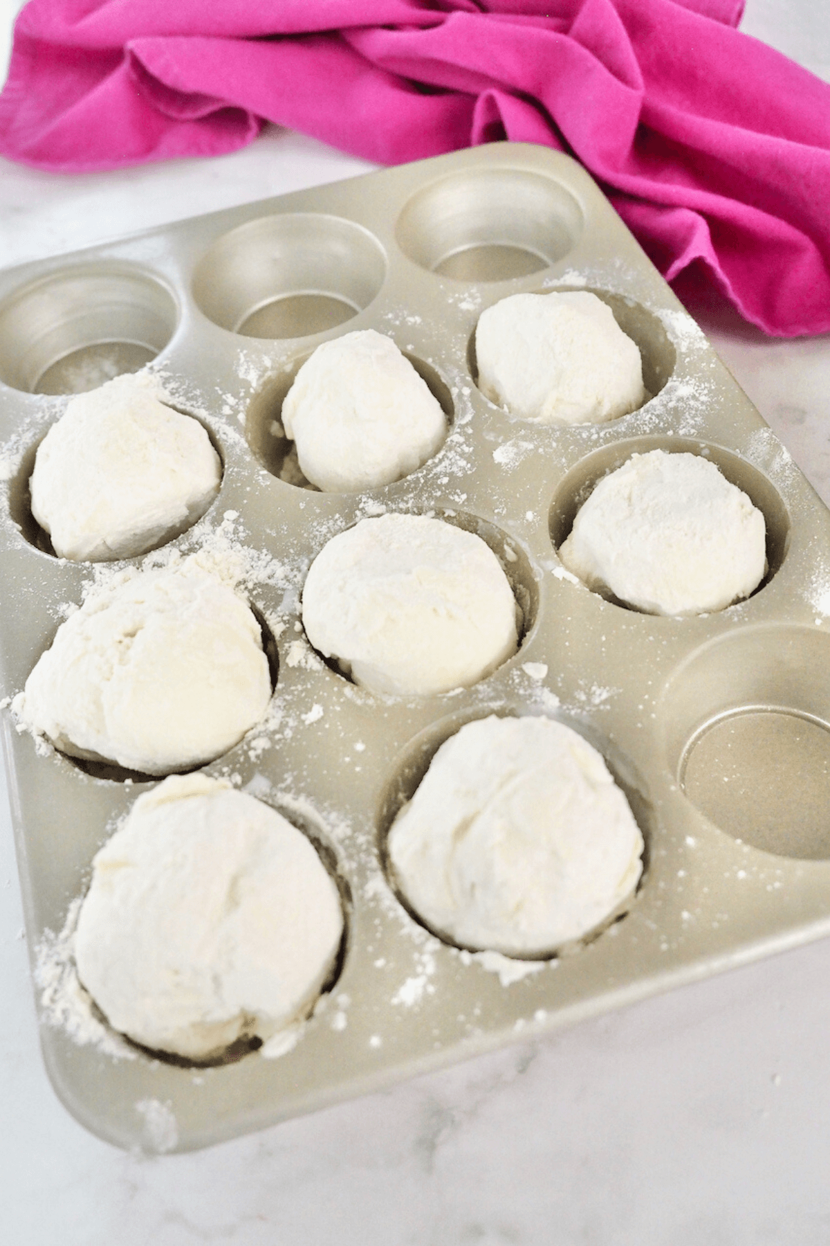 Floured frozen ice cream balls in muffin tin. 