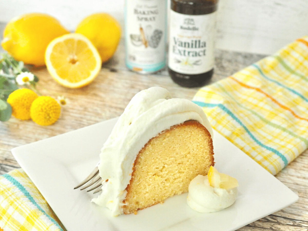 Rodelle Vanilla extract and La Tourangelle baking spray with slice of lemon bundt cake with lemons and flours behind.