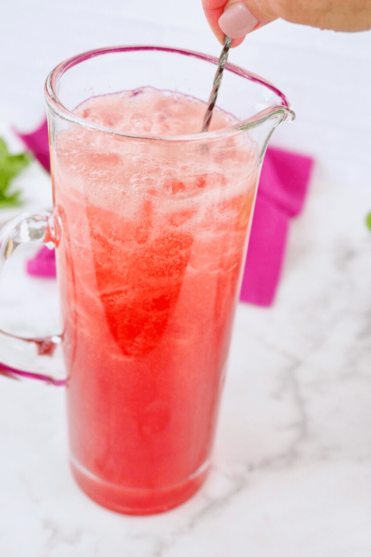 Stirring gently the pink lemonade vodka drink.