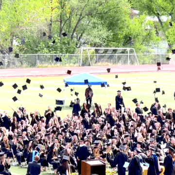 Graduation caps being thrown in the air.
