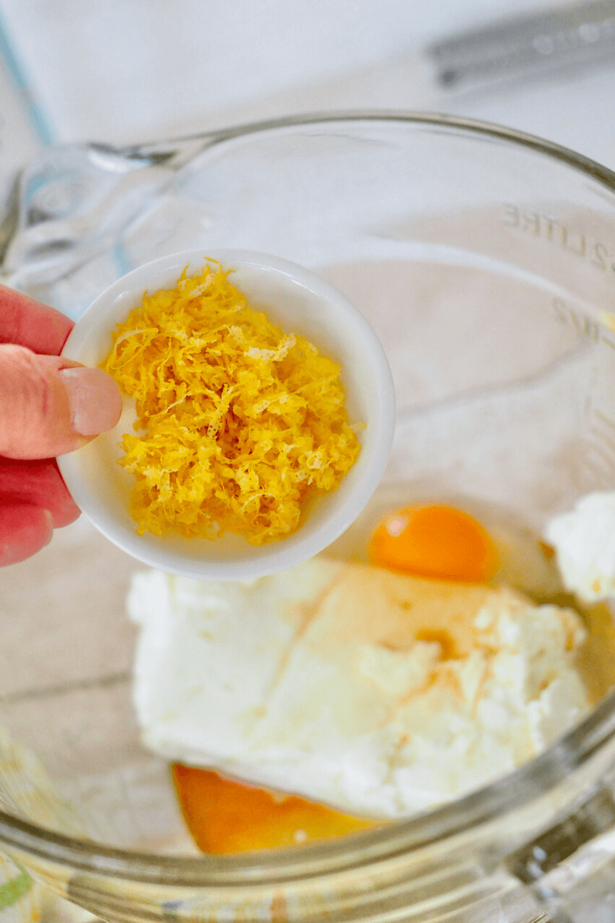 Adding lemon zest to cream cheese mixture. 