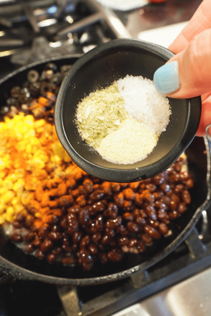 Adding onion powder, kosher salt and garlic powder into meat mixture for tamale casserole.
