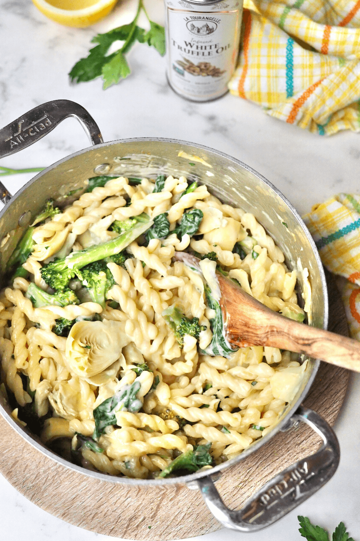 Lemon Garlic one pot pasta in pot with white truffle oil behind. 