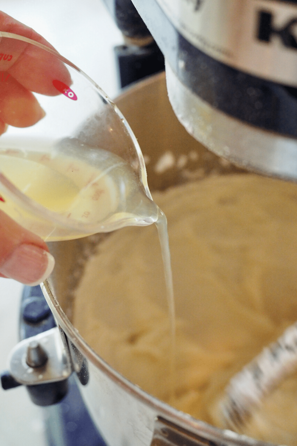 Pouring lemon juice into cream cheese frosting.