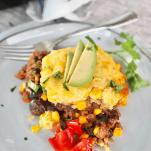 Easy tamale pie recipe slice on plate with cornbread topping.