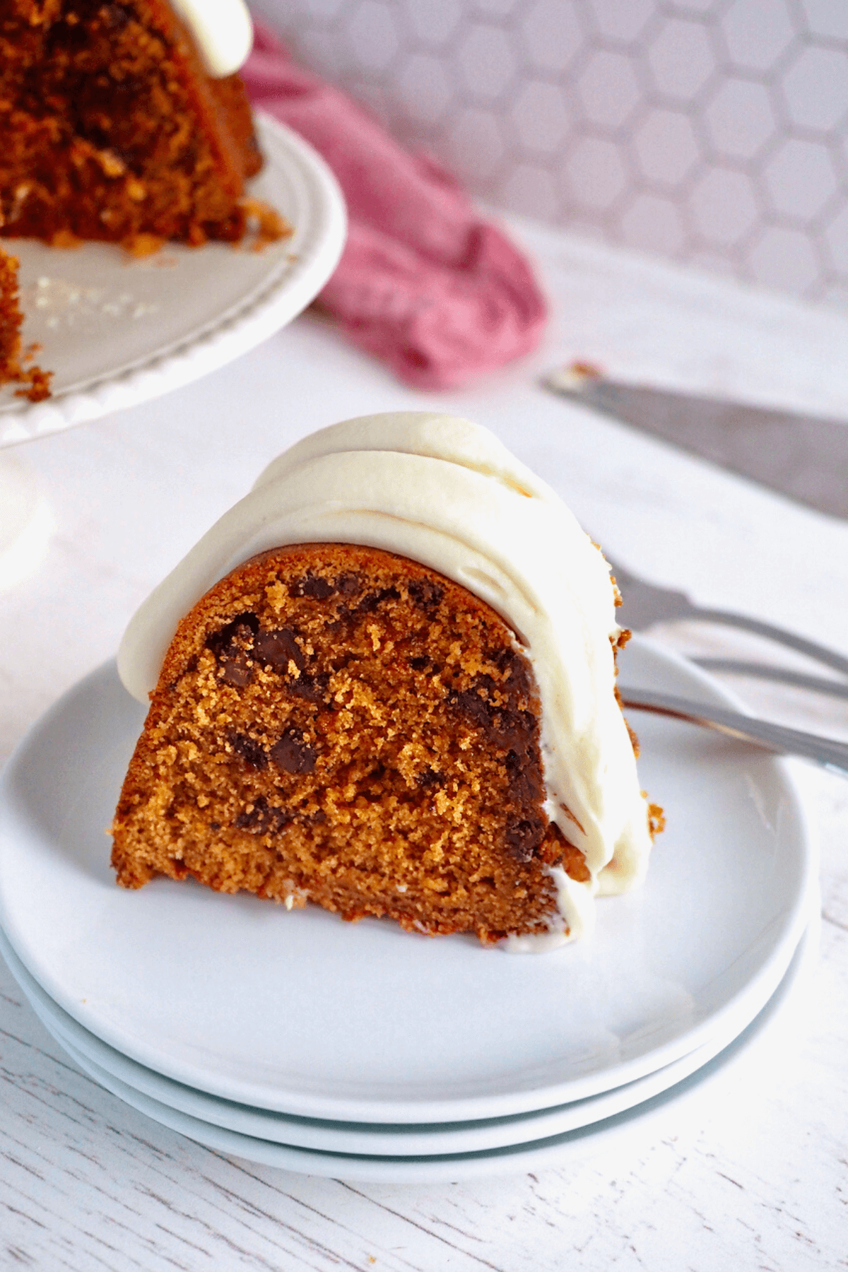 Thick slice of red velvet cake on white plates with forks behind