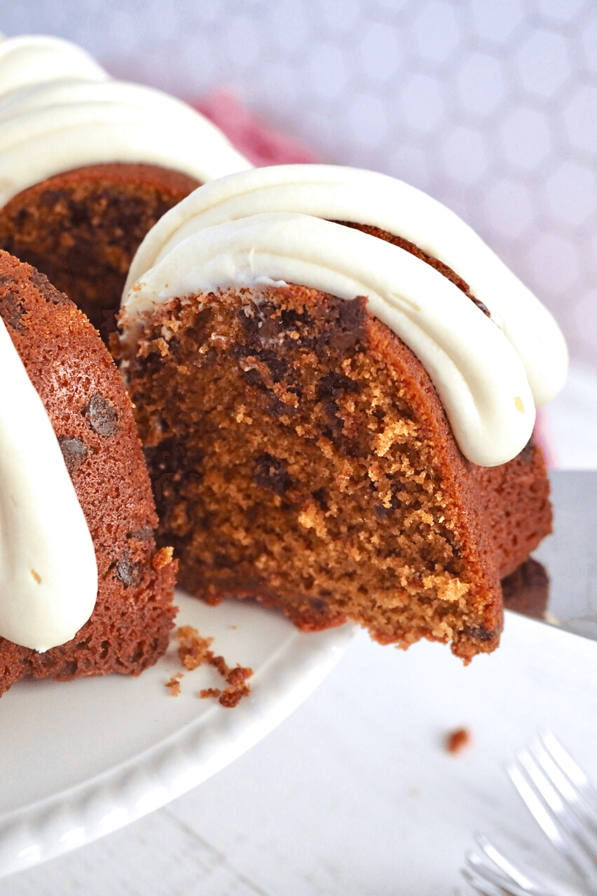 Slice being pulled from Red Velvet Cake on cream cake platter. 