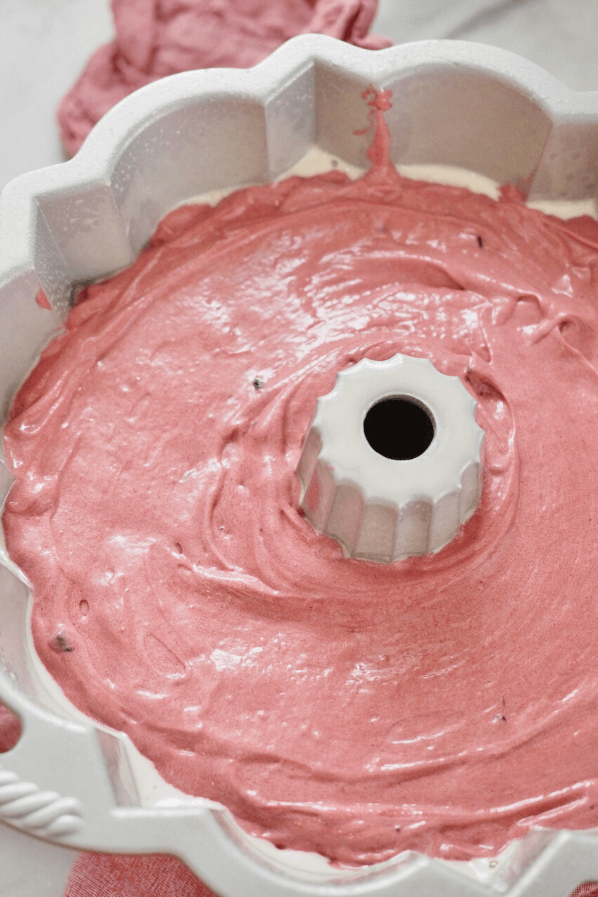 Smoothed red velvet cake batter in bundt pan. 